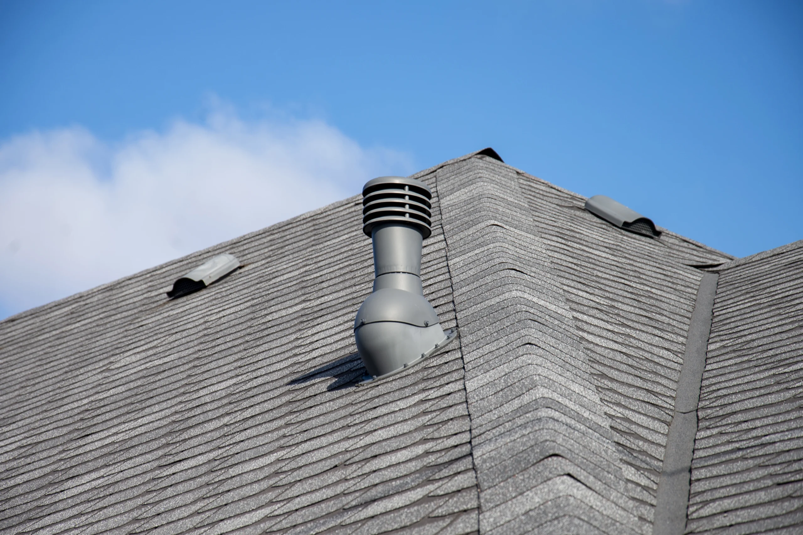 Roof ventilation components on an asphalt shingle roof